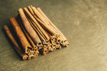 a bunch of whole sticks of fragrant cinnamon on a wooden rural table. copyspace. composition of seasoning and slide flavoring aromatic spice. close-up. top view