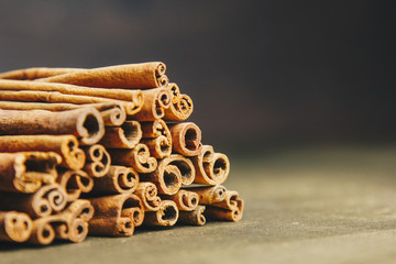 a bunch of whole sticks of fragrant cinnamon on a wooden rural table. copyspace. composition of seasoning and slide flavoring aromatic spice. close-up. side view