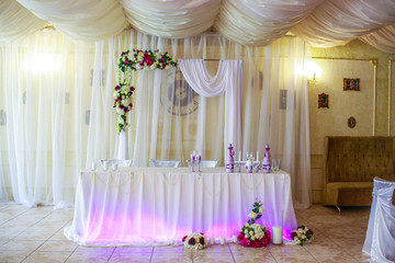 Wedding arch over the table newlyweds in the restaurant. Wedding table in the restaurant