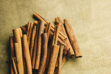 a bunch of whole sticks of fragrant cinnamon on a wooden rural table. copyspace. composition of...