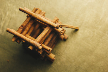 tower of whole sticks of fragrant cinnamon on a wooden rural table. copyspace. composition of seasoning and slide flavoring aromatic spice. close-up. top view, macro