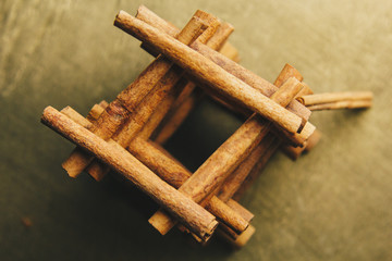 tower of whole sticks of fragrant cinnamon on a wooden rural table. copyspace. composition of seasoning and slide flavoring aromatic spice. close-up. top view, macro