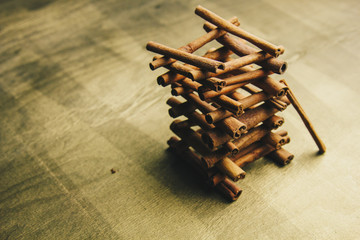 tower of whole sticks of fragrant cinnamon on a wooden rural table. copyspace. composition of seasoning and slide flavoring aromatic spice. close-up. top view, macro