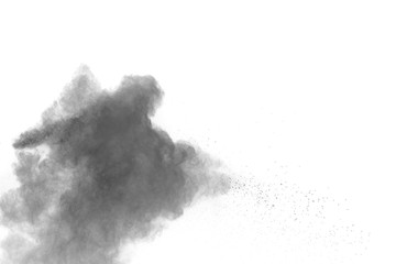 Black powder explosion against white background. Charcoal dust particles exhale in the air.