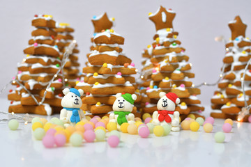 gingerbread Christmas tree.Christmas Gingerbread cookie with multi-colors caramel.Sugar white bears in red hat on white background next to multi-colors caramel