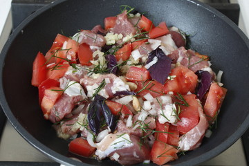 Pan with raw beef, tomatoes, dill, garlic, onion, basil, lemon juice