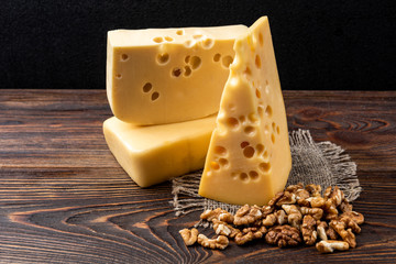 Cheese and walnut on dark wooden background. 