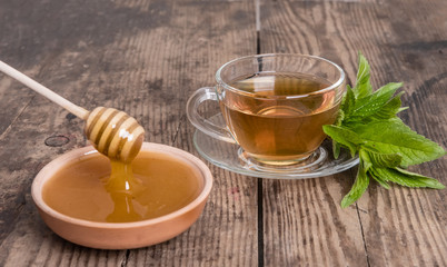 Cup of green tea mint honey on wooden background