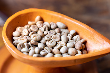 close up selective focus  raw green coffee bean in pottery cup