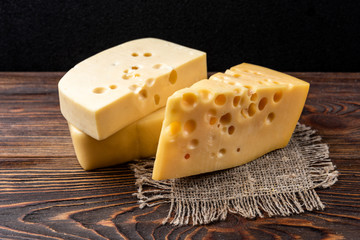 Cheese on dark wooden background. 