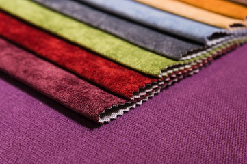 Colorful and bright fabric samples of furniture and clothing upholstery. Close-up of a palette of textile abstract stripes of different colors