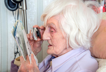 Visually impaired elderly woman with magnifyer