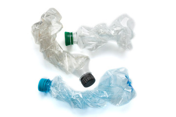 Flattened empty used plastic PVC bottles isolated on white background. Crumpled bottle - recycle eco concept.