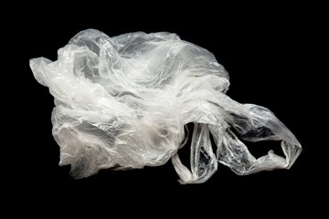 Fototapeta premium Plastic bag with handles on a black background isolate. Used plastic bag for recycling. Recycling of plastic waste into pellets as a business.