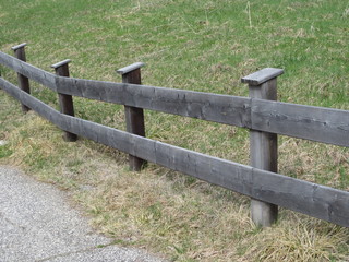 Grauer Zaun der zwei Wiesen trennt