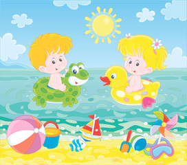 Happy little kids swimming in inflatable rings in blue water on a sea beach on a sunny summer day, vector illustration in a cartoon style