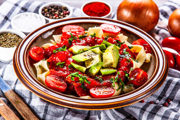 Pasta with herbs and vegetables on wooden background