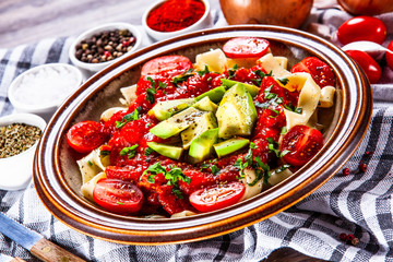 Pasta with herbs and vegetables on wooden background