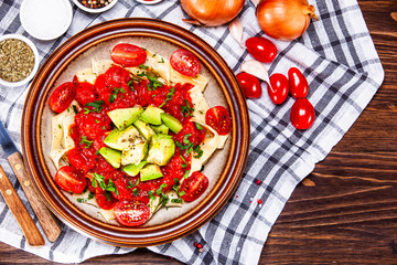 Pasta with herbs and vegetables on wooden background