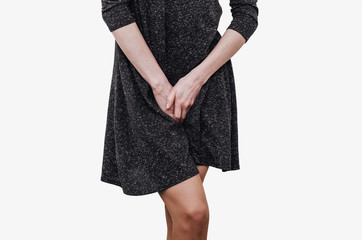 Slender girl in a dark dress experiences discomfort in the uterus, pain, hands between her legs....