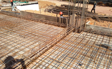 Floor slab and beam reinforcement bar under fabrication at the construction site by workers. It is...