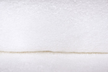 White delicate soft background of fur plush smooth fabric. Clean white new terry towel rolled blanket textile