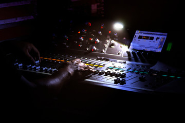 DJ at the mixing console, low light, selective focus