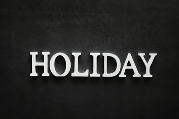 Background concept. The inscription holiday on a dark background.