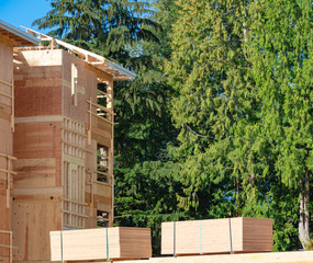 Apartment building under construction with two trunks of timber stored beside