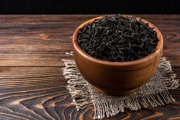 Black tea on dark wooden background. 