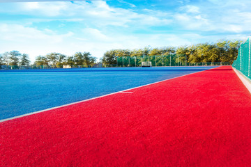 Modern Astroturf / artificial grass hockey field in red and blue