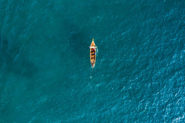 View from above, aerial view of a beautiful long tail boat sailing on a turquoise sea. Phi Phi Islands, Maya Bay, Krabi Province, Thailand.