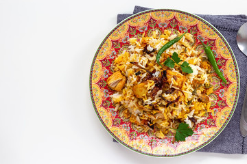 Halal Indian chicken Biryani served with yogurt tomato raita over white background. Selective focus. Top view.