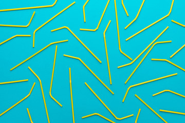 top view of cocktail straws on turquoise blue background