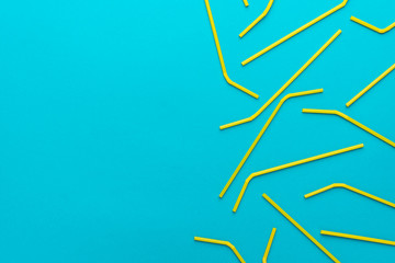 top view of cocktail straws on turquoise blue background with copy space