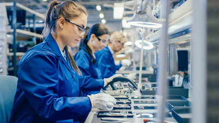 Female Electronics Factory Workers in Blue Work Coat and Protective Glasses Assembling Printed...