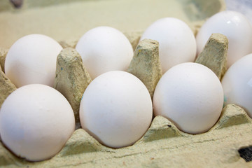 White eggs on wooden background. The Symbol Of Easter. Eggs in a cardboard box.