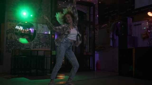 carefree crazy girl dancing on the dance floor in a nightclub.