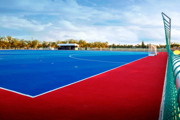 Fototapeta na wymiar Modern Astroturf / artificial grass hockey field in red and blue