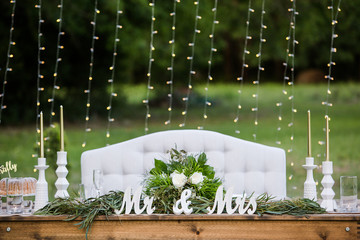Wedding Sweetheart Table with Mr and Mrs Sign, Flowers and a White Couch