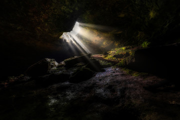 Underground cave "the stairs" in Bulgaria with sun rays from hole in cave entrance