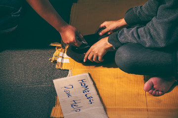 Obraz premium Beggars, Homeless people sitting on the floor, Discouraged and desperate, ask for a fraction of money from people travelng to buy food to live, to homeless concept.