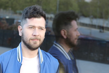 Cute man and his reflection in outdoor mirror 