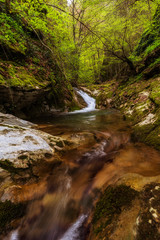 Beautiful mountain waterfall, low view from river