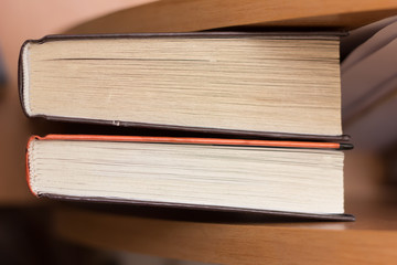 closeup of two books lying on wooden table.