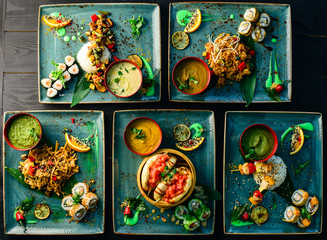 asian cuisine, lunch on a tray top view on a black table food background