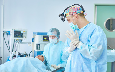 Several doctors surrounding patient on operation table during t
