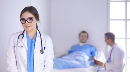 Fototapeta premium Doctor checking heart beat of patient in bed with stethoscope