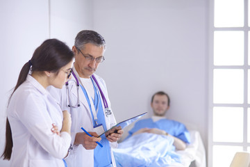 Doctor checking heart beat of patient in bed with stethoscope