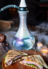 Advertising shares of hookah and delicious dishes in a restaurant with food. Hookah with hearty toasts